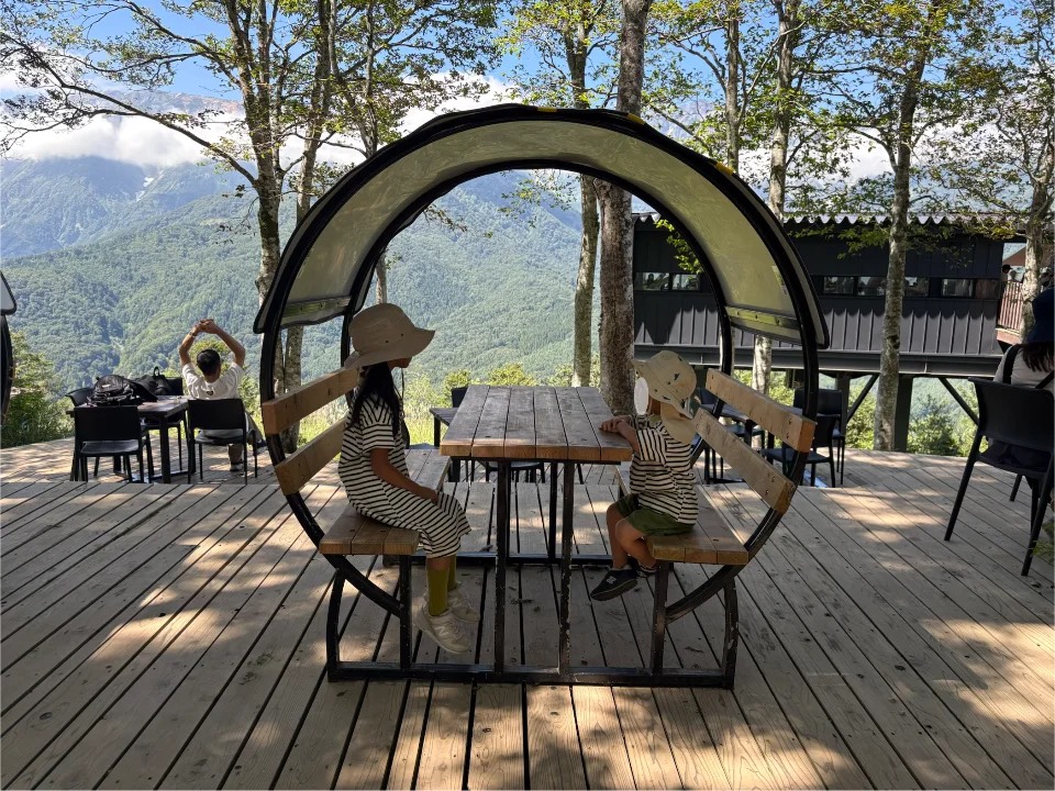 白馬マウンテンリゾートのベンチに座る子どもたち