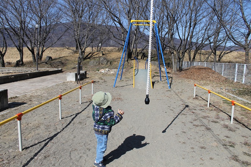 千曲市の五十里公園のターザンロープに手を伸ばす3歳児