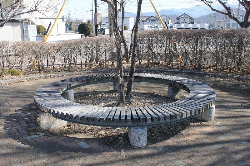 千曲市の五十里公園の木の周りにある木製ベンチ