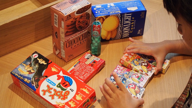ホテルタングラムのキョロちゃんルームのお菓子を並べる子どもの手