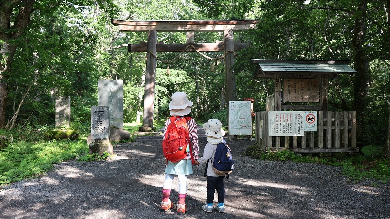 戸隠神社奥社参道の入口にある鳥居の前にたつ子どもたち