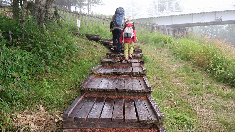 美ヶ原高原の遊歩道の木道を歩く親子