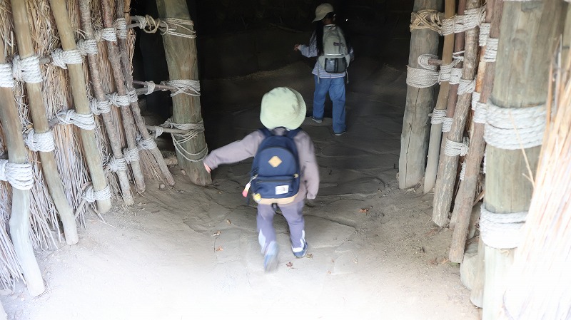 縄文時代の住居の内部を見学する子ども